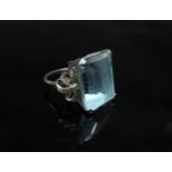 A white gold ring set with a large aquamarine, 2cm x 1.5cm with diamond studded "bow" shoulders,