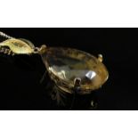 A large pear shaped citrine pendant, 4cm long in 14ct gold mount with later applied 18ct gold leaf