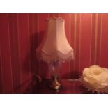 A clear glass bodied table lamp with brushed brass base, pink tasselled shade, 69cm tall, Collectors