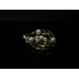 An 18ct gold brooch of leaf form set with four pearls and five diamond chips, 13g