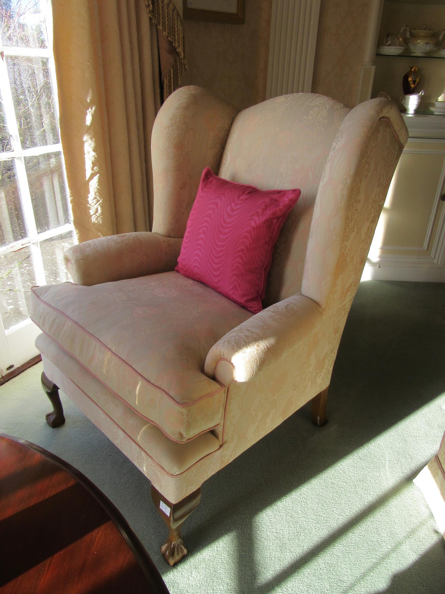 A pair of Georgian style wingback armchairs with feather filled seat cushions, silk upholstery, ball