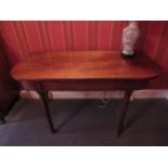 A George III mahogany side table with rounded corner top over ring turned tapering legs to