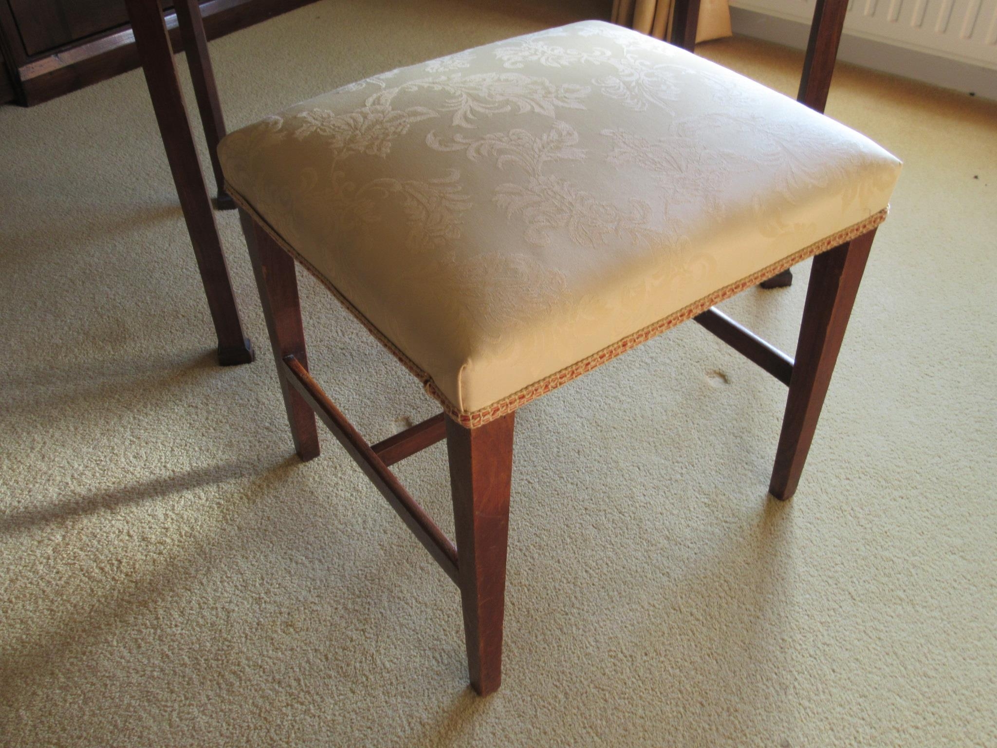 A 19th Century stool with over stuffed silk cushioned seat, square tapering legs joined by H-