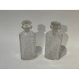 A pair of crystal decanters with melon fluted stoppers, chips present 19.5cm tall