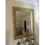 A modern ornate gilt leaf and berry bordered overmantal mirror with bevelled glass, 86cm x 66cm