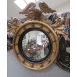 A Regency gilt circular mirror with ball detail surmounted by an eagle with acanthus leaf