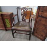 A Georgian mahogany armchair with carved acanthus leaf pierced central splat over a leather seat and