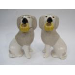 A pair of late 19th/early 20th Century Staffordshire poodles holding baskets, 22.5cm tall