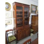 A George III mahogany two door glazed bookcase over single drawer two cupboard door base. Ebonised
