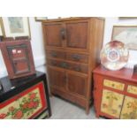 An antique Chinese cupboard with two doors above three drawers over two door base with carved