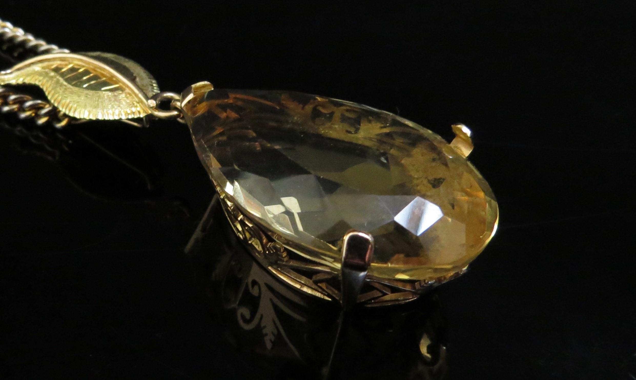 A large pear shaped citrine pendant, 4cm long in 14ct gold mount with later applied 18ct gold leaf