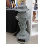 A bronze Chinese floor standing incense burner with dragon high relief detail on domed footed