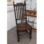 A Charles II oak solid seat country high-back chair with scroll crest with repairs present
