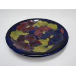 A Moorcroft Clematis pattern plate on blue ground, 26cm diameter