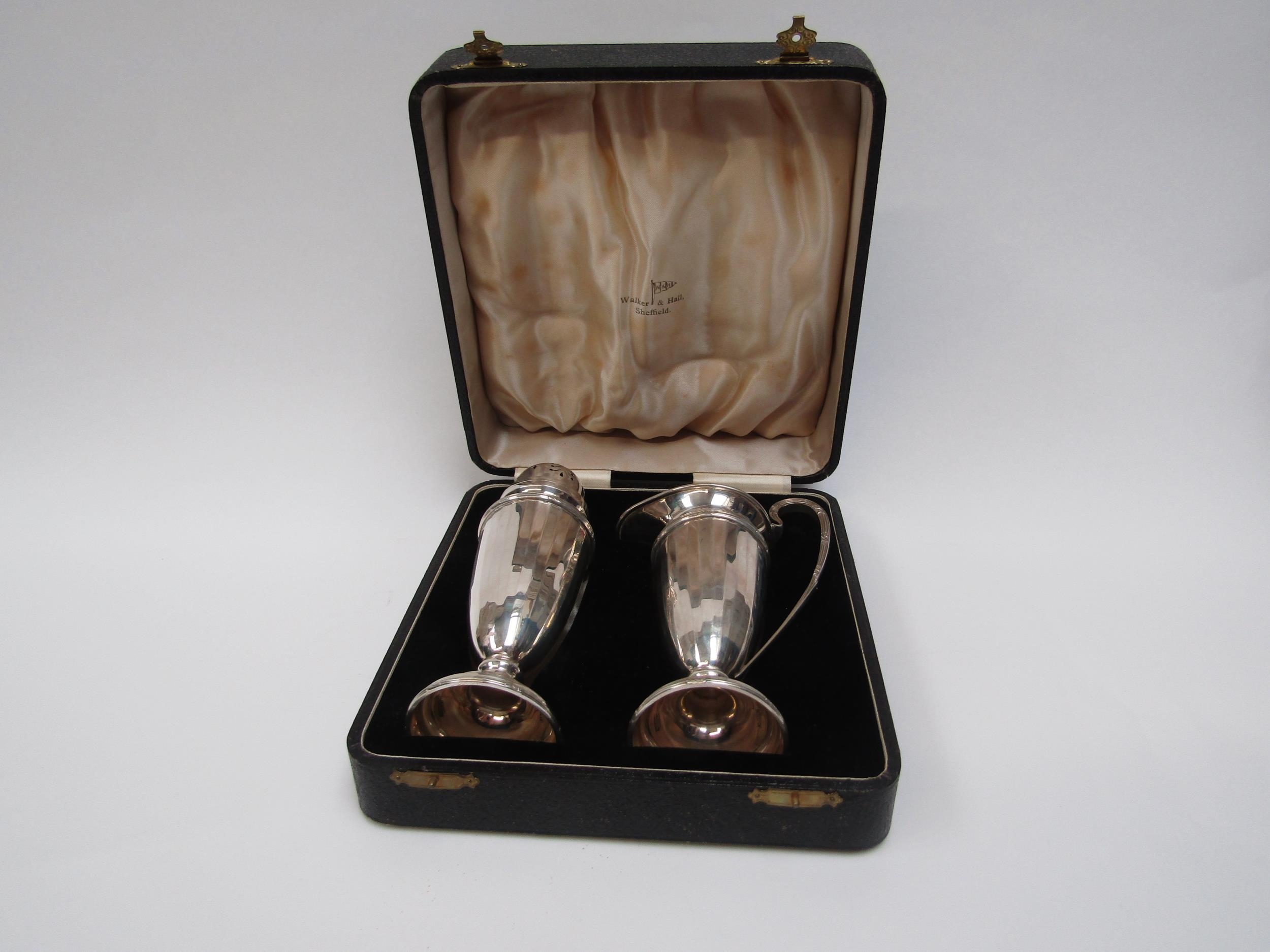 A Walker and Hall silver two piece sugar castor and cream jug set, Rd 713654 Sheffield 1963,