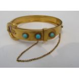 A high carat gold buckle hinge bangle with turquoise cabochons, unmarked, 17.7g