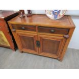 An antique Chinese sideboard with two drawers and two cupboard doors, character mark to doors,