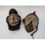 Two African masks with white painted faces, 33cm & 34cm tall
