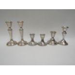 Two pairs of silver candlesticks and two others all with weighted bases