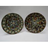 A pair of Continental glazed and painted clay wall plates, 26.5cm diameter