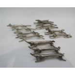 A set of twelve anamorphic knife rests including pigs, hares, stags and dogs