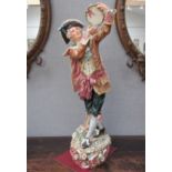 An early 20th Century ceramic figure of a gent with tambourine, 78cm height