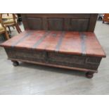 An Indian hardwood coffee table with storage compartment to the interior, metal strapping and