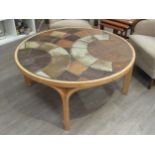 A Danish circular coffee table with stoneware tiled top by Haslev and laminated ply frame. Marks