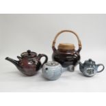 A collection of studio pottery including three teapots of various sizes and glazes and a large