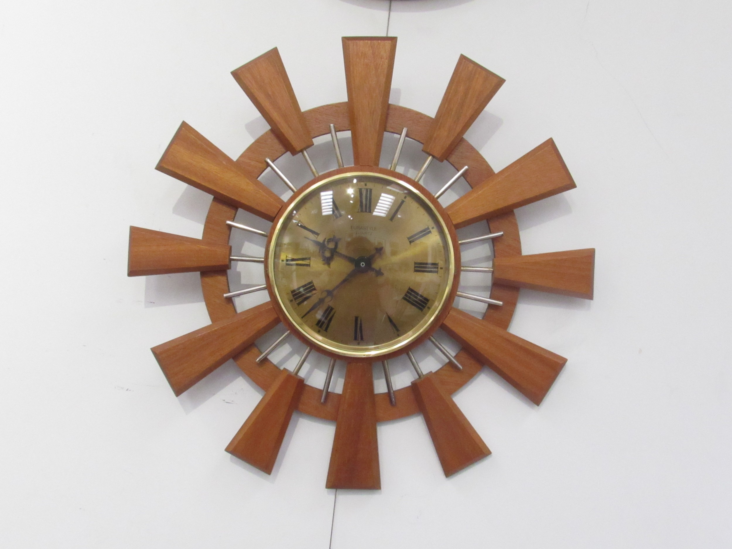 A sunburst wood and metal wall clock, 41.5cm diameter