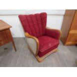 A 1940's Danish armchair, original embossed upholstery in red, stained oak arms and feet. 80cm x