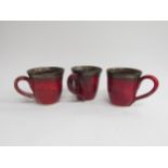 Judith Swannell - Three studio pottery mugs with artists hand painted marks to base. 9.5cm high