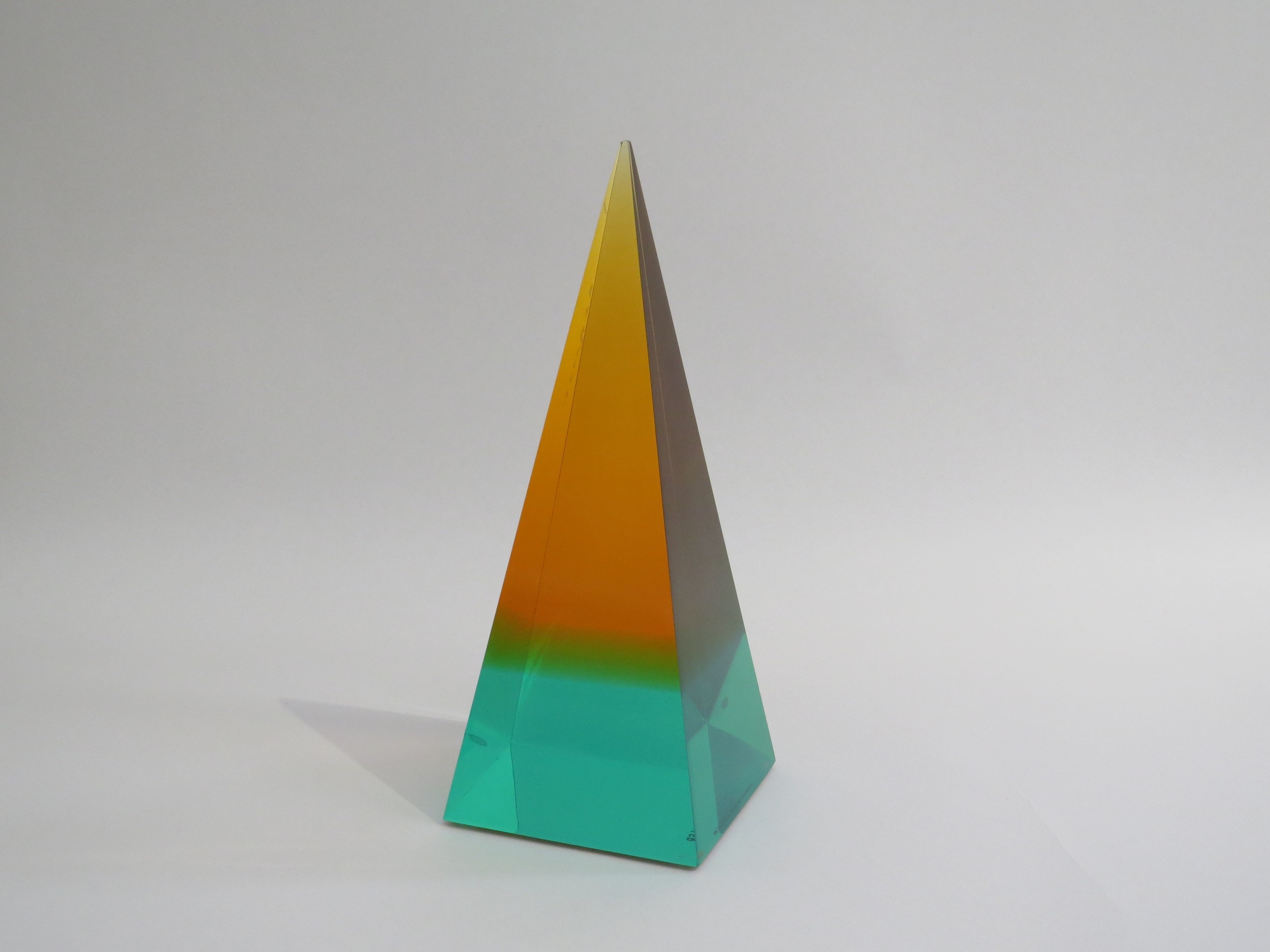 A Jonathan Adler Lucite obelisk in turquoise, green and orange colours. 26cm high