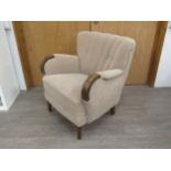 A 1940's Danish armchair original embossed upholstery in oatmeal colours, dark stained wooden arms