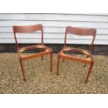 A pair of Danish teak dining chairs, seat pads removed as do not conform with current Fire Safety