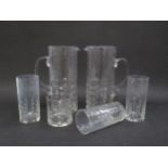 Two Kosta Boda clear glass Lemonade jugs with three matching tumblers and a single glass. Moulded