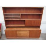A Danish teak sideboard with bank of four drawers flanked by cupboards with raised top with