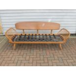 An Ercol light elm sofa "Day Bed" with plank back. No seat pads, 206cm x 77cm x 76cm high