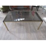 A Danish rectangular brassed square metal framed coffee table with smoked glass top. 120cm x 65cm