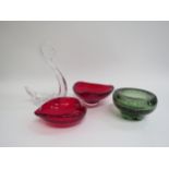 A collection of Whitefriars glass dishes in Ruby and green and a clear glass swan. Tallest 22cm