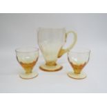 A Whitefriars 1940's amber lemonade jug, M74, together with two glasses. Jug 19cm high