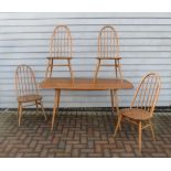 An Ercol light elm dining table and four high hoop back chairs. Table 152cm x 77cm x 71cm high
