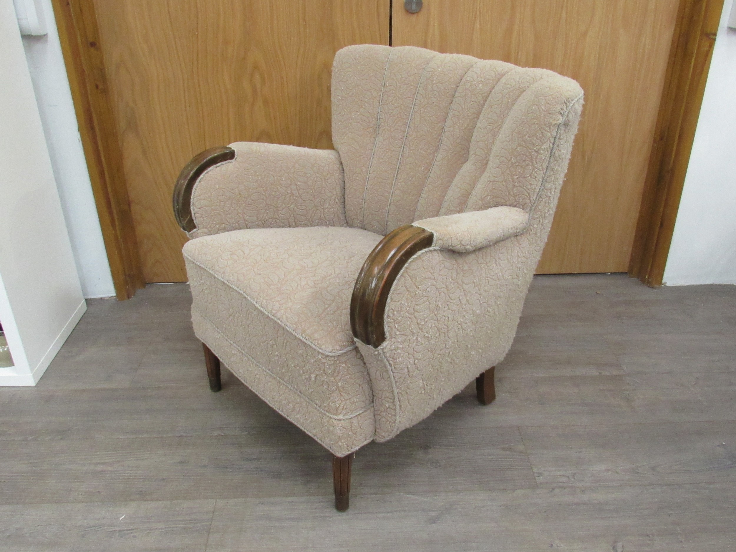 A 1940's Danish armchair original embossed upholstery in oatmeal colours, dark stained wooden arms