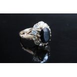 A gold sapphire and diamond cluster ring, the central sapphire 10mm x 7mm framed by ten 0.10ct