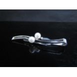 A Mikimoto silver tie clip set with two pearls