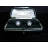 A pair of pearl and diamond earrings, the central pearl 5mm diameter framed by diamonds, for pierced
