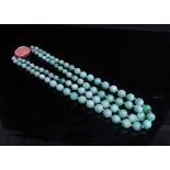 A jade bead necklace with carved coral clasp, 38cm long