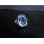 A 9ct gold ring the textured mount set with an oval topaz. Size O, 8g