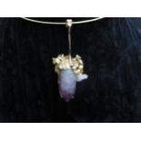 A torq necklace stamped 750, hung with abstract gold pendant set with rough cut amethyst wands. 36.