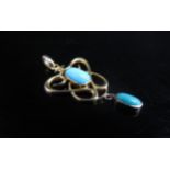 An Edwardian style gold pendant set with an oval turquoise and hung with a turquoise droplet,